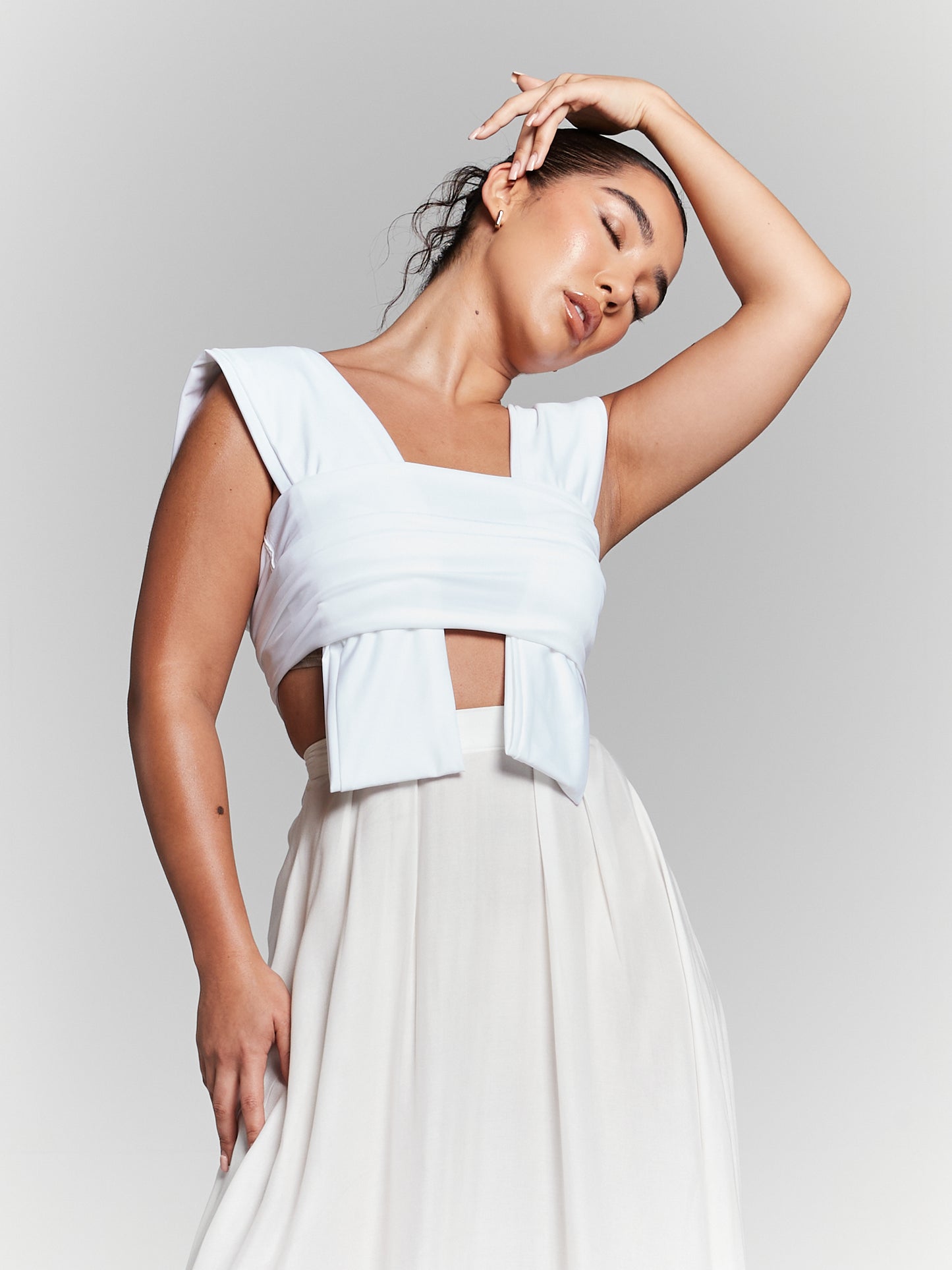 A versatile multiway tie top made from recycled viscose fabric. The top features adjustable straps, allowing it to be worn in various styles. The fabric is a sustainable blend of recycled materials, promoting eco-friendly fashion. The design is chic and suitable for diverse occasions multiway tie blouse multiway tie top Adjustable strap top Versatile tie top multi tie stripy cropped top stripy crop top multiway tie crop top ivory multiway top