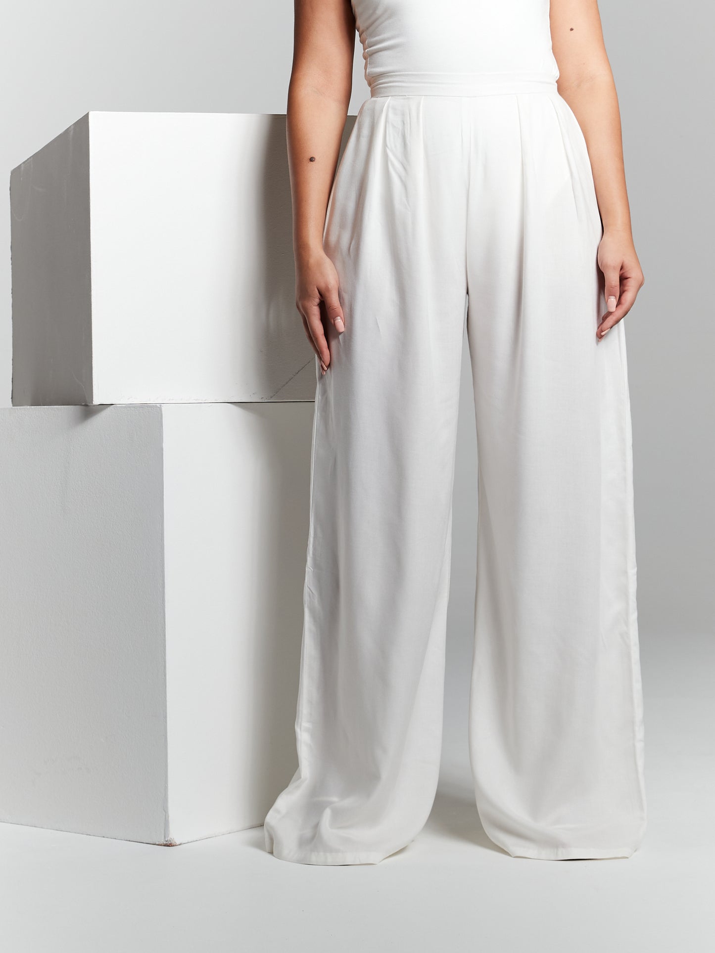 High waisted invisible zip closure high rise fit fitted on waist flared from waist to hem high rise box pleated pressed pleat wide leg straight leg trousers made from recycled eco rayon viscose that is lightweight soft and breathable. Trouser is suitable for beach holiday city break wedding guest hen party registry office wedding office garden party poolside 