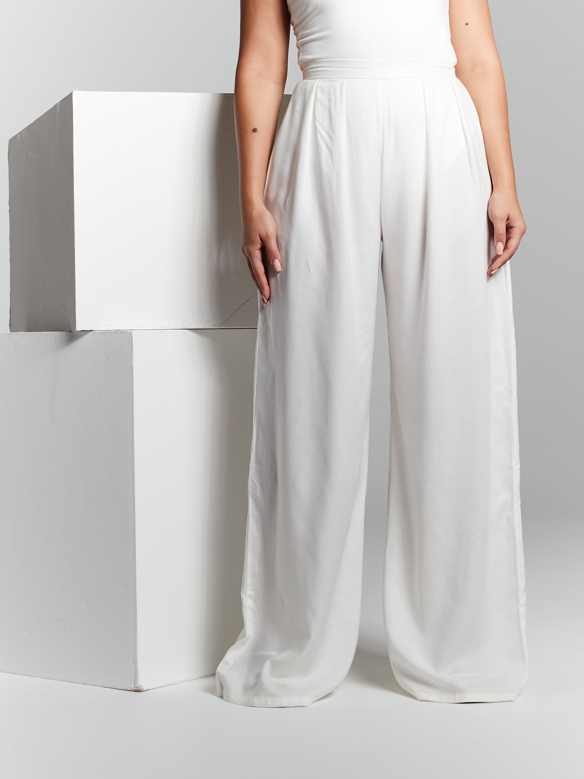 High waisted invisible zip closure high rise fit fitted on waist flared from waist to hem high rise box pleated pressed pleat wide leg straight leg trousers made from recycled eco rayon viscose that is lightweight soft and breathable. Trouser is suitable for beach holiday city break wedding guest hen party registry office wedding office garden party poolside 
